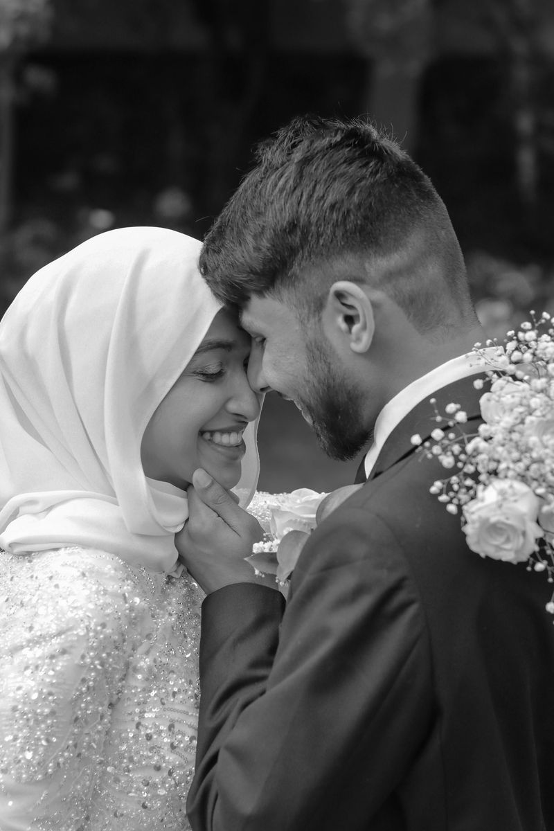 Black and white portrait of a bride and groom resting their foreheads together