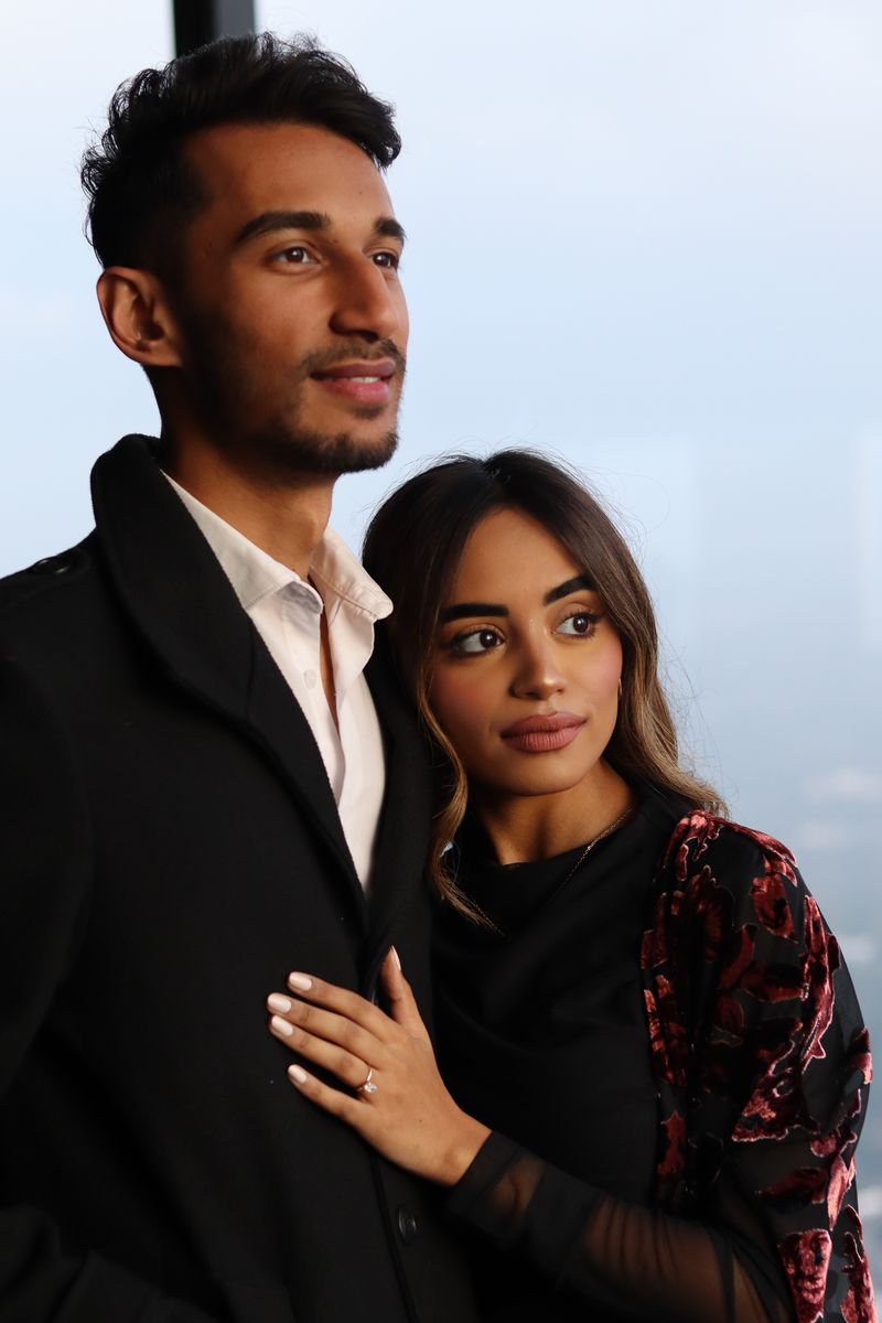 A couple photographed after the proposal, the new ring on her hand